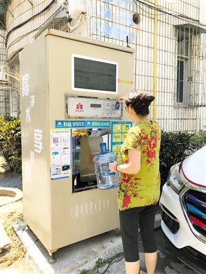 5月24日,琼山区上丹花苑小区居民陈女士在使用共享净水机取水。 本报记者 陈歆卓 摄